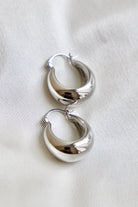 Pair of silver hoop earrings on a white background
