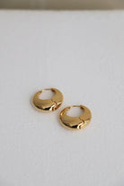 Gold hoop earrings on a light gray background