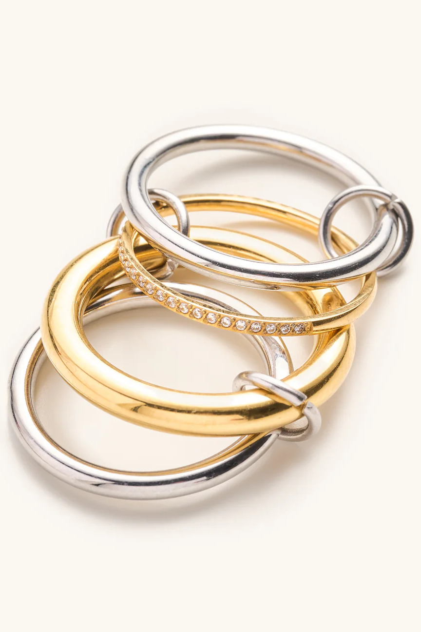 Three interlocking rings in gold, silver, and rose gold on a white background