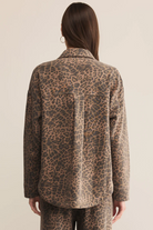 Person wearing a leopard print jacket on a beige background