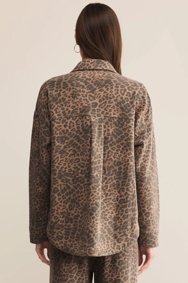 Person wearing a leopard print jacket on a beige background