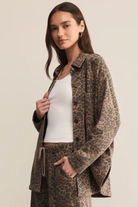 Woman wearing a leopard print coat and pants on a beige background