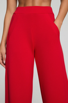 Red pants worn by a person on a plain background