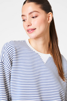 Woman wearing a blue and white striped shirt against a white background