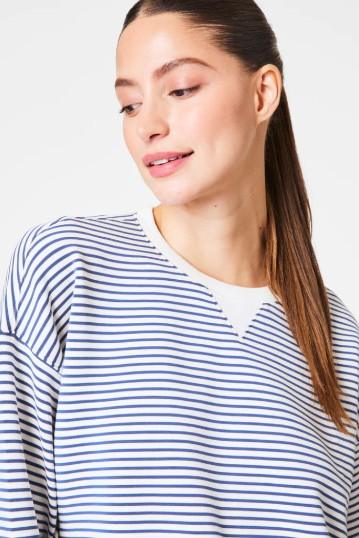 Woman wearing a blue and white striped shirt against a white background