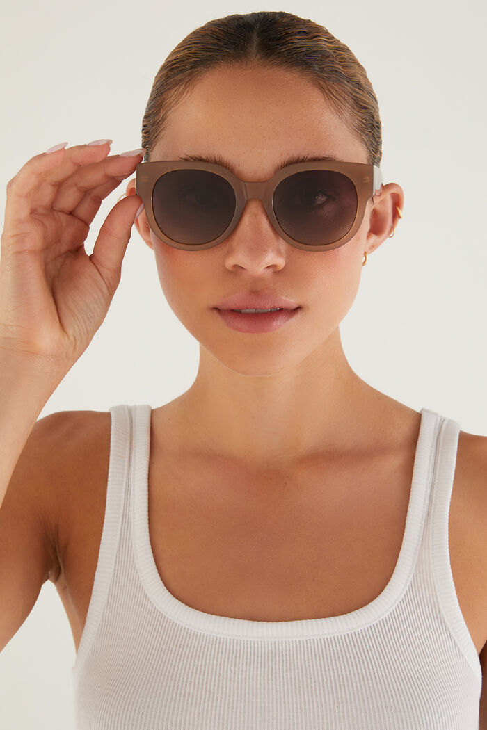 Woman wearing sunglasses with a plain background