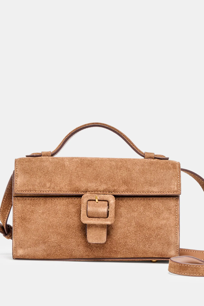 Brown suede handbag with a buckle on a light gray background