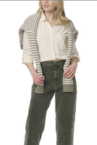 Person wearing a beige shirt, green pants, and a striped shawl on a white background