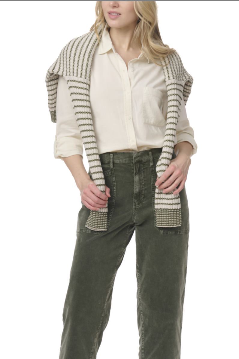 Person wearing a beige shirt, green pants, and a striped shawl on a white background