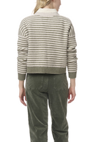 Person wearing a striped sweater and green pants on a white background