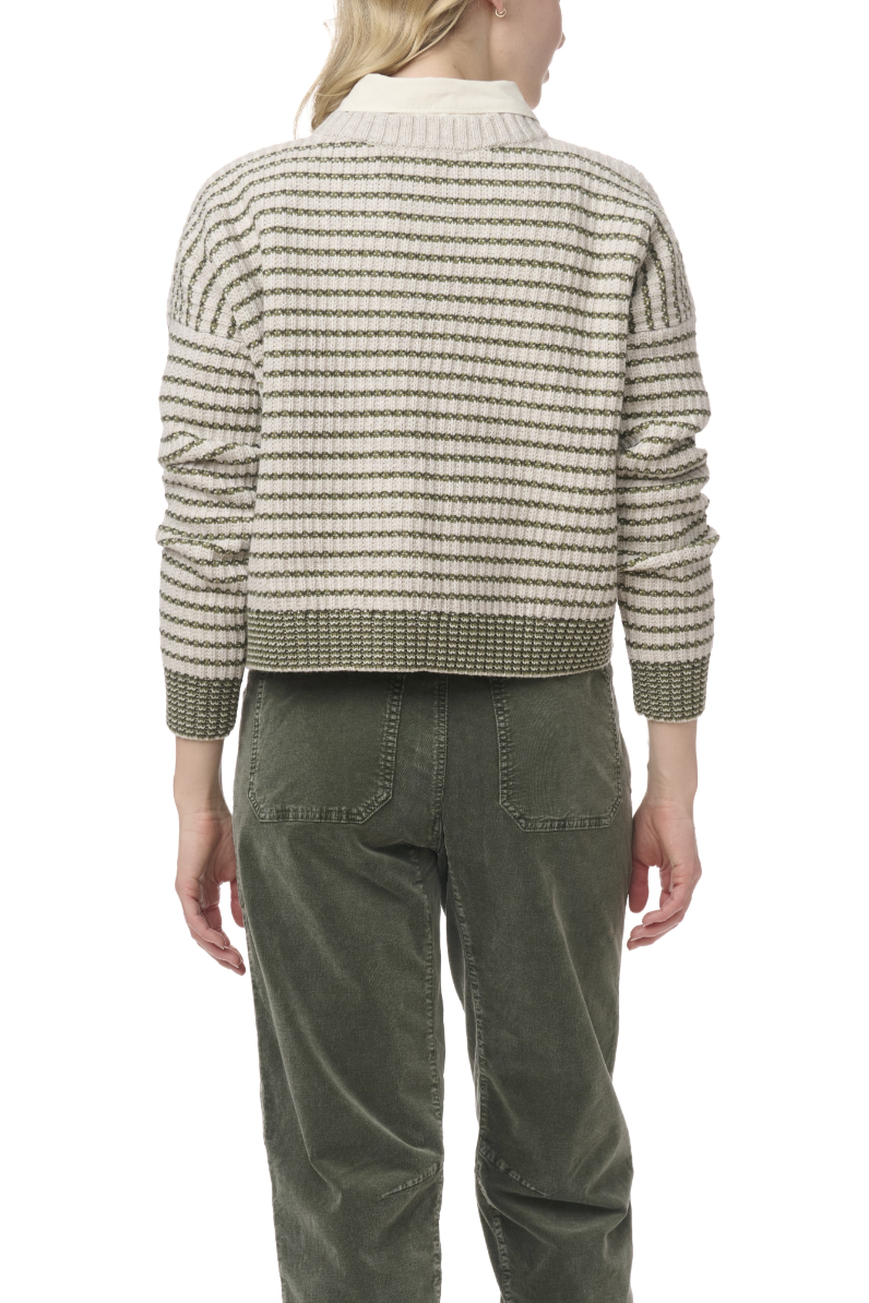 Person wearing a striped sweater and green pants on a white background