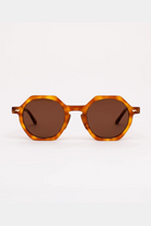 Sunglasses with tortoiseshell frame and brown lenses on a white background