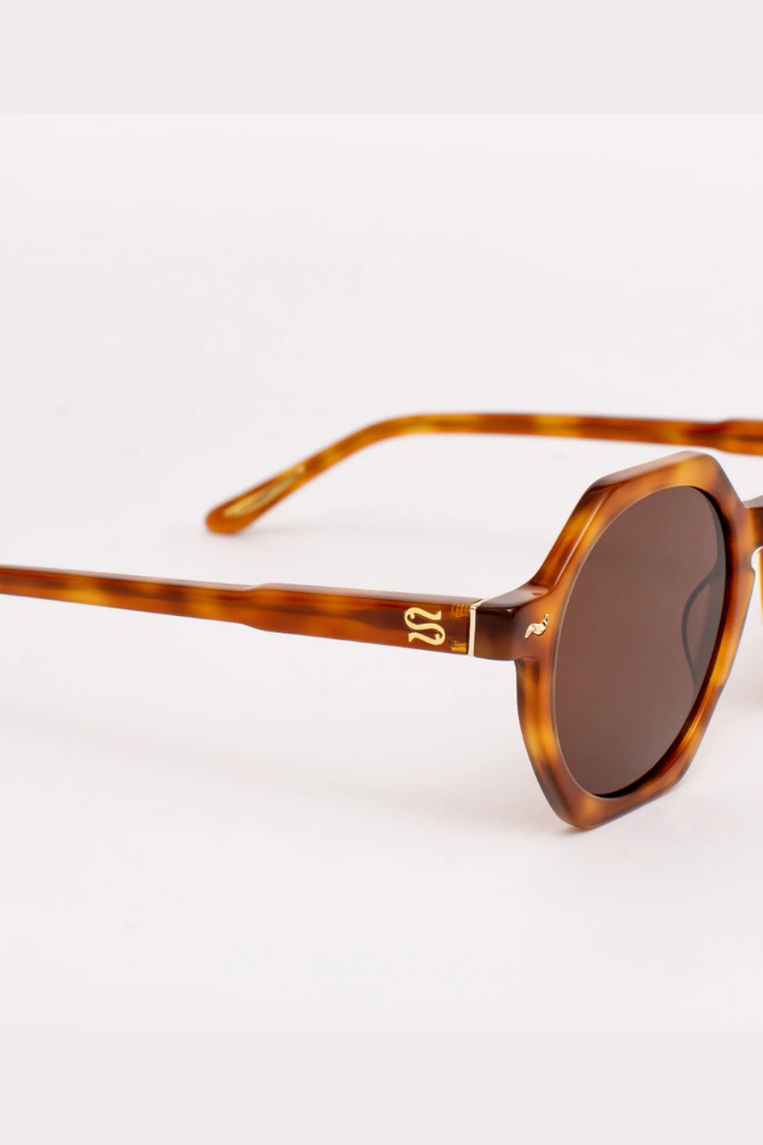 Sunglasses with tortoiseshell frame and dark lenses on a white background