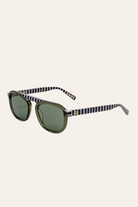 Sunglasses with checkered arms on a light beige background