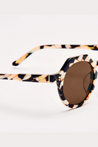Sunglasses with tortoiseshell frame and brown lens on a white background