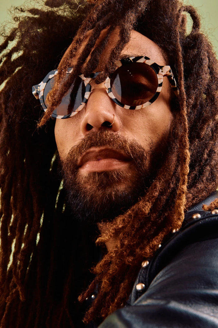 Person with dreadlocks wearing sunglasses and a leather jacket