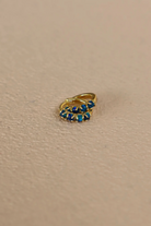 Gold ring with blue gemstones on a beige background