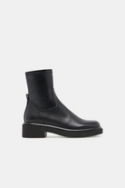 Black Chelsea boot on a light gray background