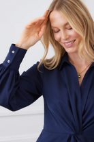 Woman wearing a navy blue dress with a white background
