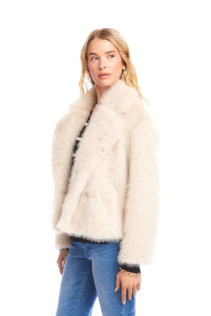 Woman wearing a cream fur jacket on a white background