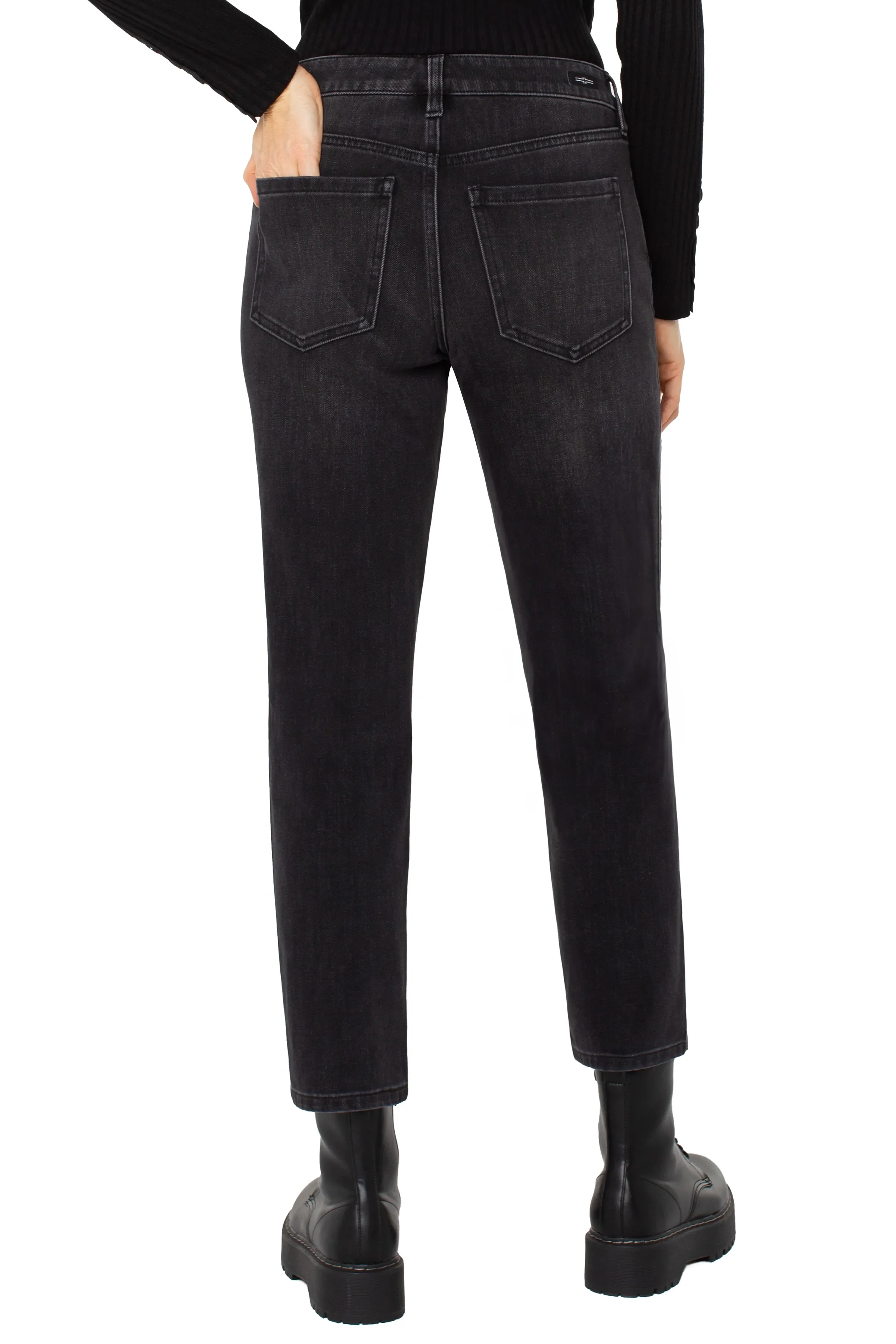 Person wearing black jeans and black shoes on a white background