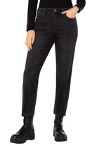 Person wearing black high-waisted jeans and black boots on a white background