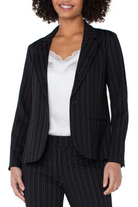 Woman wearing a black pinstripe suit with a white top on a white background