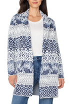 Woman wearing a patterned cardigan over a white shirt and jeans