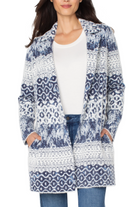Woman wearing a blue and white patterned cardigan over a white shirt and jeans.