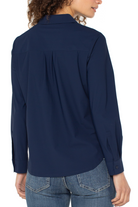 Navy blue shirt worn by a person on a white background