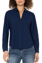 Woman wearing a navy blue long-sleeve shirt and jeans on a white background