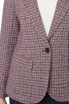 Close-up of a textured blazer with a single button on a white background