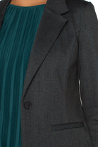 Dark gray blazer worn over a teal dress
