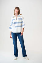 Woman wearing a blue and white striped shirt and blue jeans on a white background