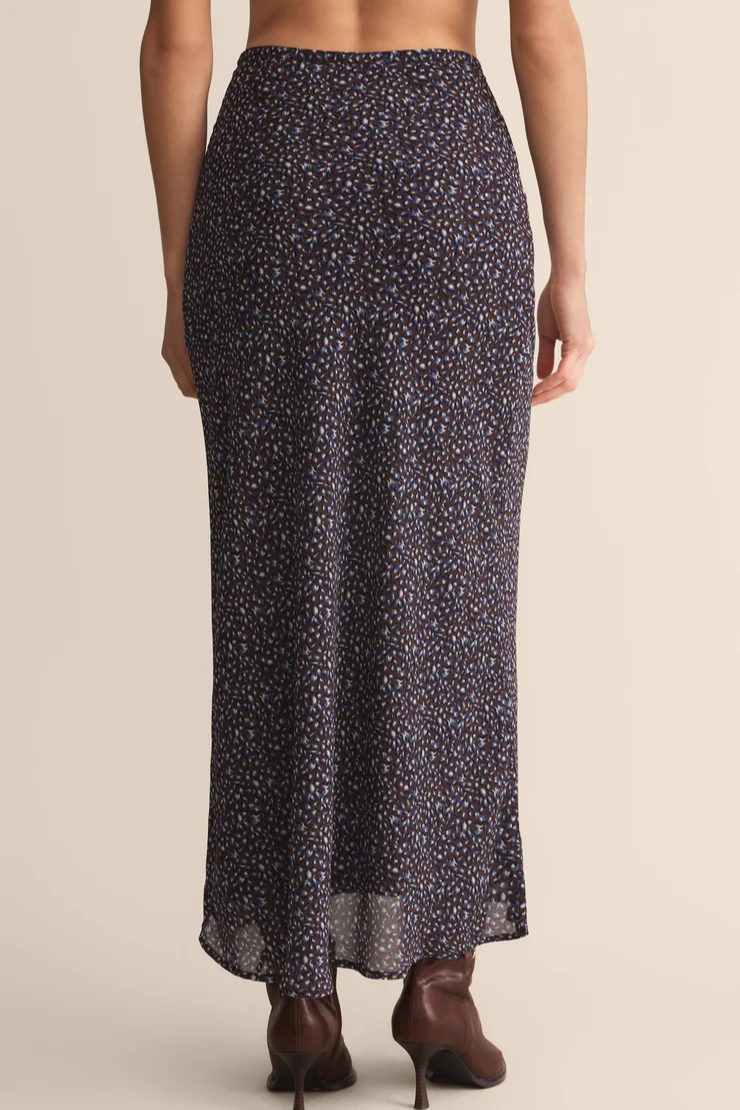 Long patterned skirt worn by a person on a beige background