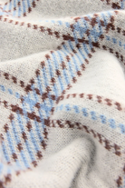 Close-up of fabric with blue and brown pattern on a white background