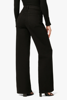 Black pants worn by a person on a white background