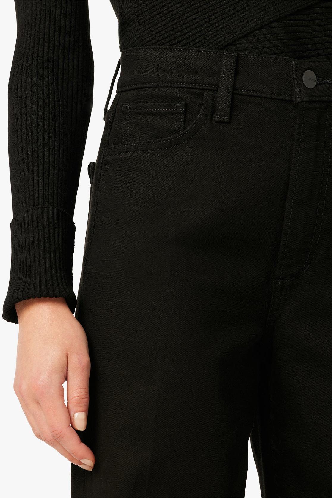 Close-up of black pants with a person wearing a black sweater.