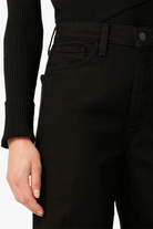 Close-up of black pants with a person wearing a black sweater.