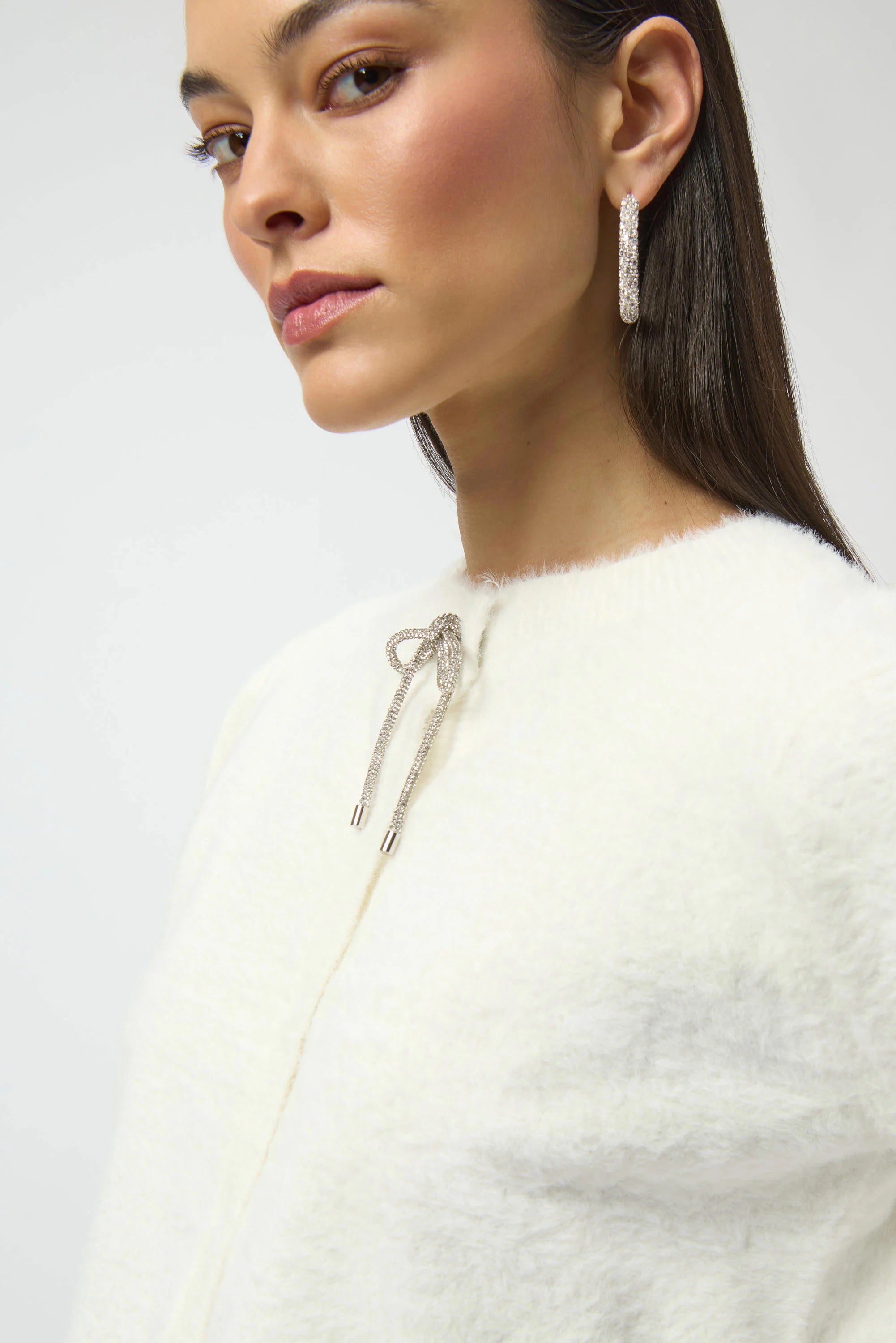 Close-up of a woman wearing earrings with a plain background