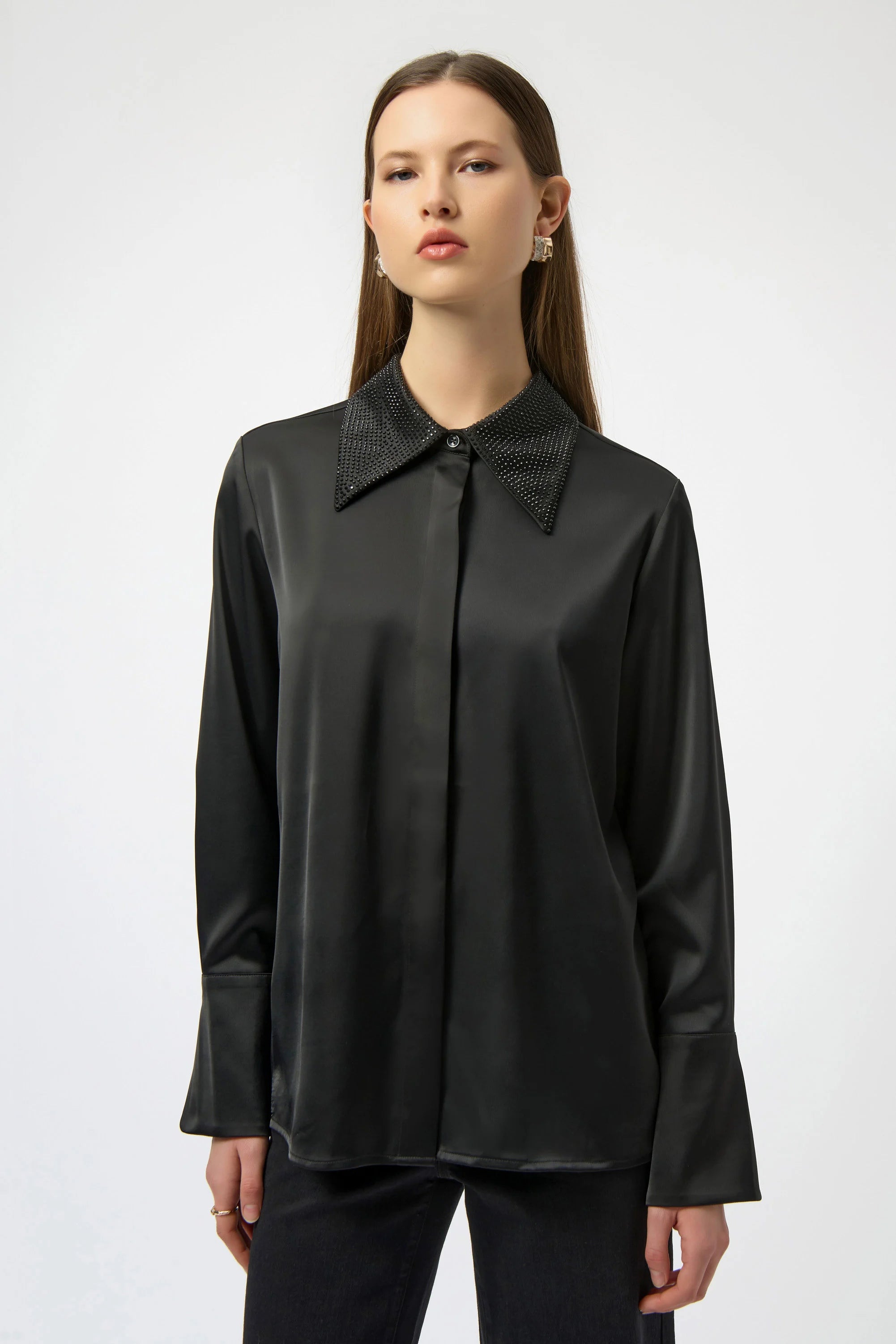 Woman wearing a black blouse with a high collar on a white background