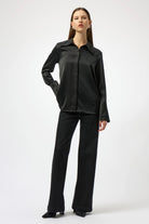 Woman wearing a black shirt and pants on a white background