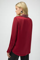 Woman wearing a red blouse with a textured collar on a white background