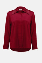Red blouse with embellished collar on a white background