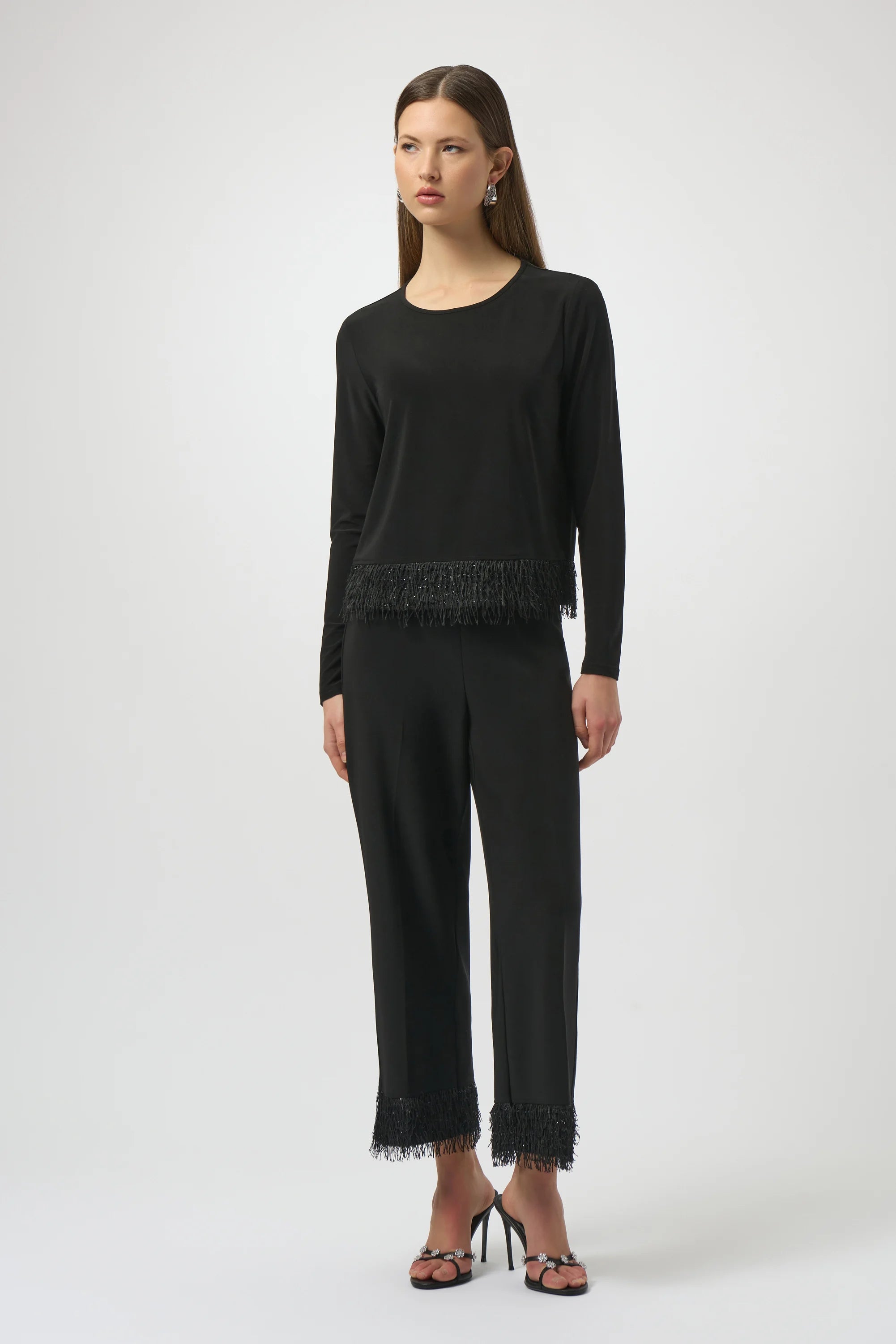 Woman wearing a black outfit with lace details on a white background