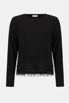 Black sweater with fringe detail on a white background