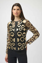 Woman wearing a black and gold patterned jacket on a white background