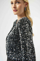 Woman wearing a black sequin jacket on a white background