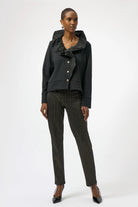 Woman wearing a black outfit with a patterned top and pants on a white background