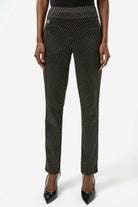 Black patterned pants worn by a person on a white background